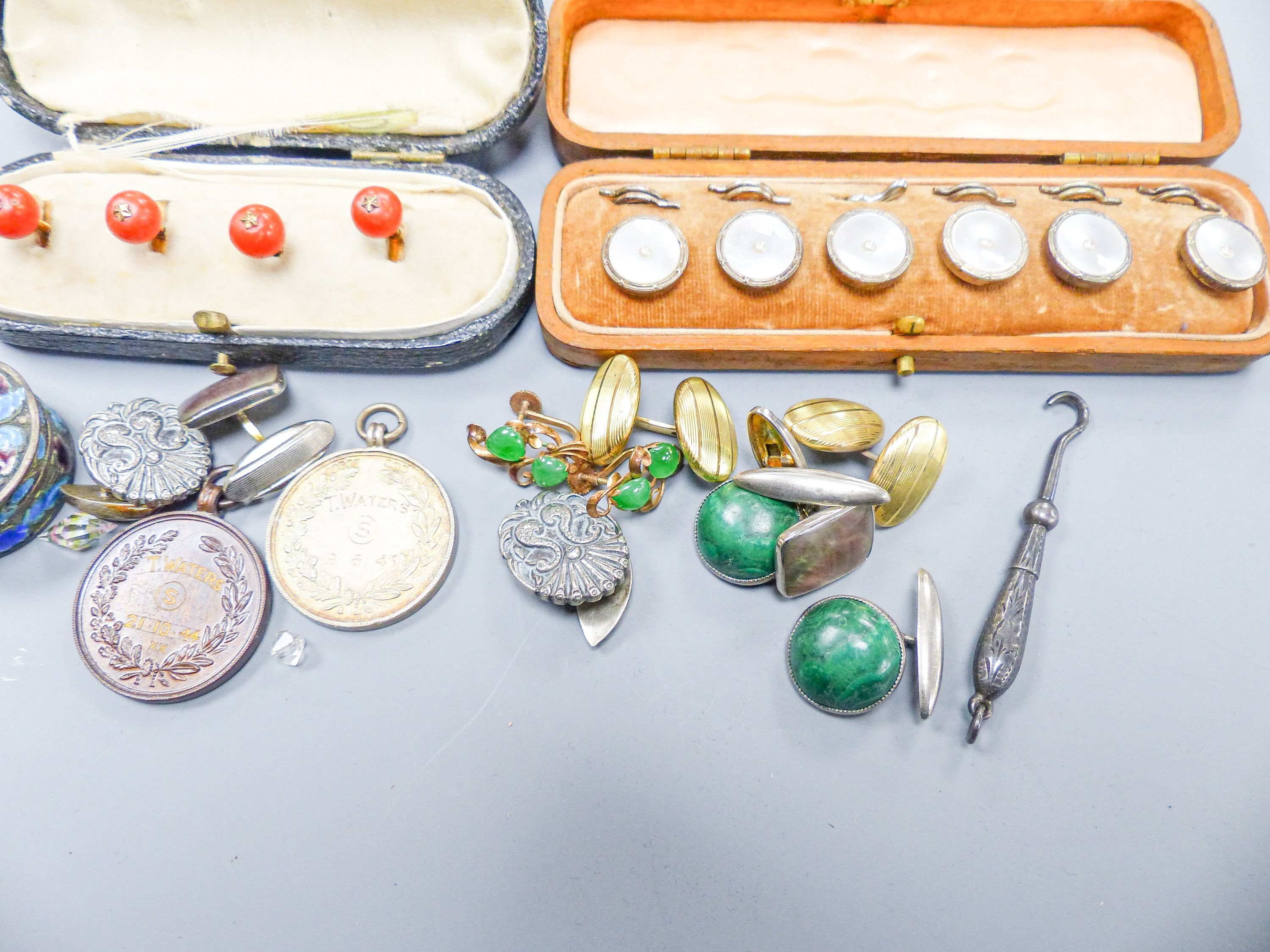 A set of four coral dress studs (cased), a set of six mother of pearl studs (cased), a pair of yellow metal cufflinks, a pair of silver cufflinks and sundry items